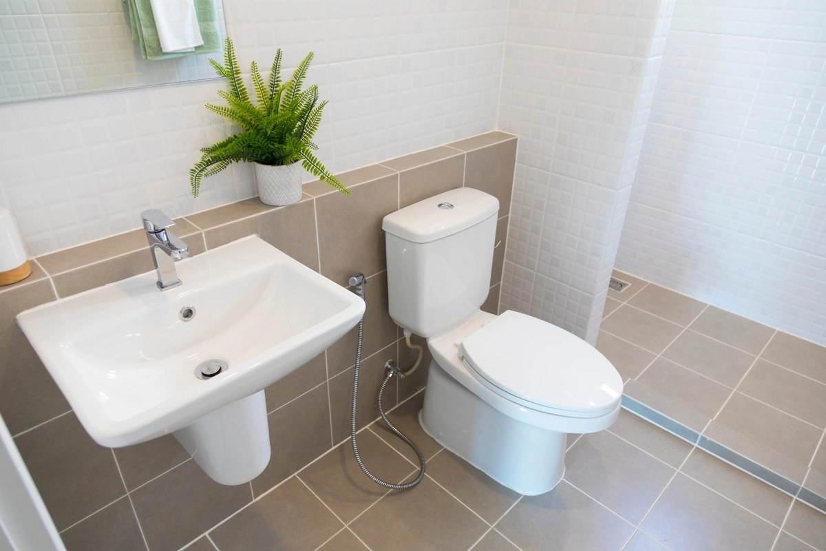 Salle de bains moderne équipée : installation de WC et lavabo par un expert en dépannage plomberie.